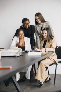 Professional women working together in a collaborative office setting, enhancing team synergy.